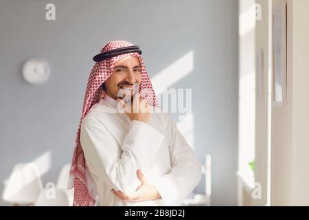 Arabischer Mann steht in einem weißen Büro. Stockfoto