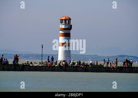 Podersdorf, Österreich - 29. April 2012: Nicht identifizierte Menschen auf Steg mit Leuchtturm am Neusiedler-See im burgenländischen Stockfoto