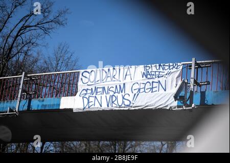 Karlsruhe, Deutschland. März 2020. Ein Banner mit der Aufschrift 'Solidarity ist unsere Waffe, zusammen gegen den Virus!! Hängt an einer Brücke in der Nähe des KSC Wildpark Stadium. GES/Alltag in Karlsruhe während der Coronakrise, 22.03.2020 GES/Alltag während der Coronakrise in Karlsruhe. 22.03.2020 in der Nähe des KSC-Wildparkstadions steht ein Banner auf einer Brücke mit Motivation zur Solidarität gegen das Virus. Weltweite Nutzung Credit: Dpa / Alamy Live News Stockfoto