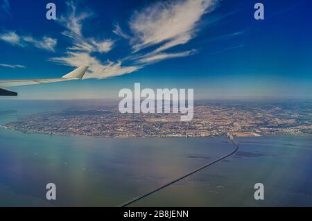 Der Landeanflug nach lissabon mit Blick aus einem Flugzeug auf die lange Vasco-da-Gama-Brücke an einem sonnigen Tag. Stockfoto