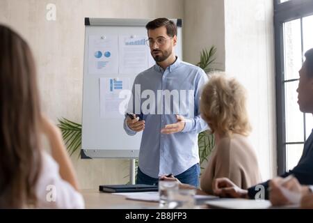 Kaukasische Lautsprecher für Männer machen Whiteboard-Präsentation im Büro Stockfoto