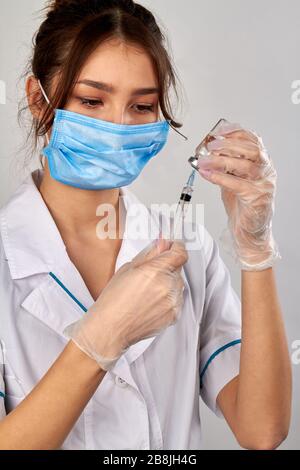 Weiblicher Arzt füllt Spritze mit Arznei aus dem Fläschchenröhrchen. Stockfoto