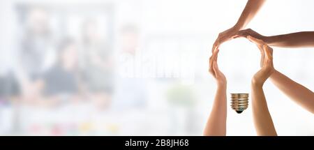 Symbol und Form der Lampe, die aus den Händen erzeugt wurde. Idee, Zusammenarbeit, Teamarbeit und kreative Lösung. Stockfoto