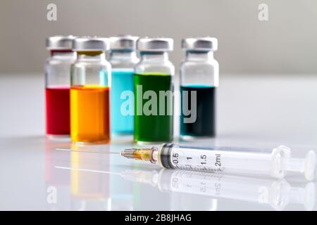 Syrynge und Flaschen mit farbiger Arznei. Stockfoto