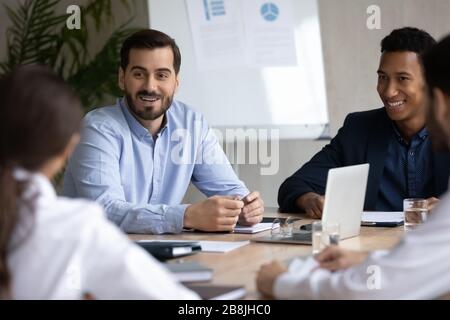 Lächelnde Geschäftsleute diskutieren bei Treffen über Geschäftsprojekt Stockfoto