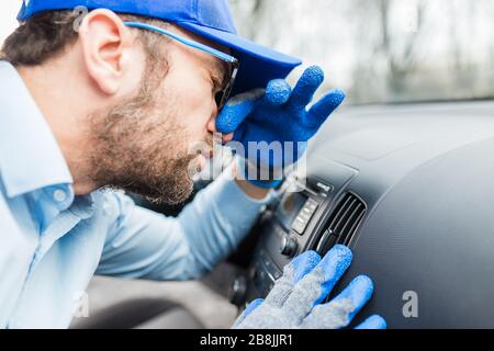 Arbeiter schützten seine Nase vor schlechter Gerüche der Autoklimaanlage. Stockfoto