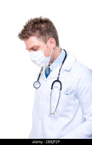 Porträt des jungen männlichen Arztes, der eine chirurgische Maske trägt Stockfoto