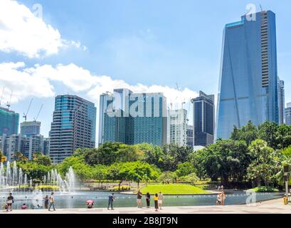 Büro- und Wohnhochhäuser und Brunnen in Symphony Lake und Touristen genießen einen Tag im KLCC Park Kuala Lumpur Malaysia. Stockfoto