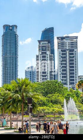 Büro- und Wohnhochhäuser und Brunnen in Symphony Lake und Touristen genießen einen Tag im KLCC Park Kuala Lumpur Malaysia. Stockfoto