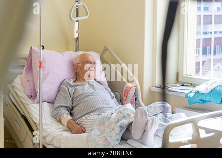 Älterer Mann, der im Krankenhaus auf ein Bett legt. Stockfoto