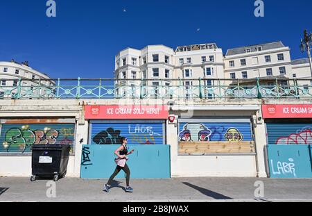 Brighton UK 22. März 2020 - EIN Läufer an der Küste von Brighton heute Morgen in Brighton, aber im kalten Frühling Sonnenschein während der Coronavirus COVID-19-Pandemie-Krise . Kredit: Simon Dack / Alamy Live News Stockfoto