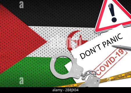 Flagge der Westsahara und Handschellen der Polizei mit Aufschrift geraten nicht in Panik auf weißem Papier. Coronavirus oder pandemic 2019-nCov Virus-Konzept Stockfoto