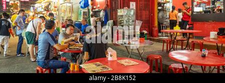 Touristen essen in einem chinesischen Restaurant am Petaling Street Market bei Nacht Kuala Lumpur Malaysia. Stockfoto