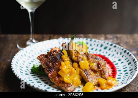 Mojito Chicken geschmorte, bonlose Hähnchenschenkel, Tangy-Rum-Reduktion, Mango-Salsa, herbetierte Tomaten und geröstete Kartoffeln Stockfoto