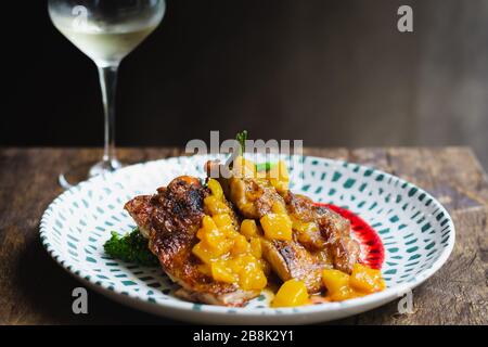 Mojito Chicken geschmorte, bonlose Hähnchenschenkel, Tangy-Rum-Reduktion, Mango-Salsa, herbetierte Tomaten und geröstete Kartoffeln Stockfoto