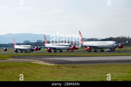 Prestwick, Schottland, Großbritannien. März 2020. Drei Airbus A340 im Besitz von Virgin Atlantic geparkt und im Lager am Flughafen Glasgow Prestwick. Viele Fluggesellschaften haben überschüssige Flugzeuge am Flughafen und in anderen Teilen Großbritanniens geparkt, weil die Passagierzahlen und Flüge während der Coronavirus Pandemie gesunken sind. Iain Masterton/Alamy Live News. Stockfoto