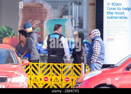 Tesco Supermarkt in Southend on Sea mit Wachmann, der die Käufer morgens in der Schlange kontrolliert. Panik beim Kauf von Einkaufserreaktionen. Wichtige NHS-Mitarbeiter Stockfoto