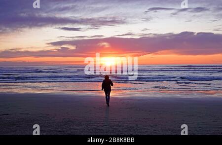 Ein Wanderer genießt einen schönen Winteruntergang entlang der Küste von Oregon in der Nähe des Dorfes Yachats, Oregon. Stockfoto