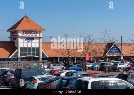 Tesco Extra Supermarkt in Southend on Sea mit einer riesigen Anzahl von Käufern, die morgens Schlange stehen. Panik beim Einkauf. Parkplatz Stockfoto