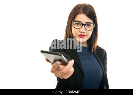 Porträt des Geschäftsmädchens mit Brille, die das Smartphone isoliert auf weißem Hintergrund mit Werbetexten aushändigt Stockfoto