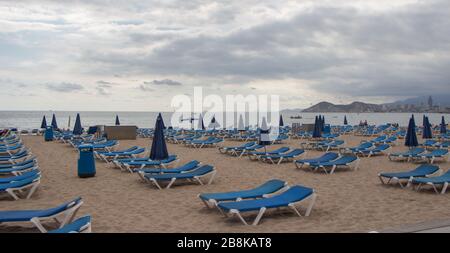 Strand mit Liegestühlen und Sonnenschirmen an einem bewölkten Tag Stockfoto