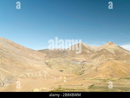 Blick über den Spiti Valley und Chicham Dorf in der Nähe von hohen Himalaya unter hellen Himmel im Sommer in der Nähe von Chicham, Himachal Pradesh isoliert, Stockfoto