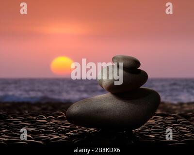 Haufen Cairn Rocks am kalifornischen Strand bei Sonnenuntergang Stockfoto