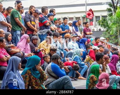 Menschenmenge sitzt auf Stufen beobachten kostenloses Konzert in Baum gesäumt Jalan Tuanku Abdul Rahman Straße im Zentrum von Kuala Lumpur Malaysia. Stockfoto
