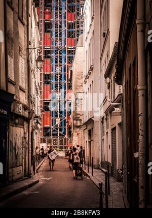 Der Kontrast einer traditionellen Pariser Hinterstraße mit den postmodernen Pfeifen und Schloten des Centre Pompidou im Hintergrund, Paris, Frankreich Stockfoto