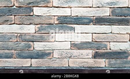 Graue, weiße, schwarze, braune wand aus Backstein im chinesischen Stil. Hintergrund der alten schmutzigen Wandstruktur aus Backstein. Horizontaler Blick auf eine Mauer aus Backstein. Hintergrund mit Kopie Stockfoto