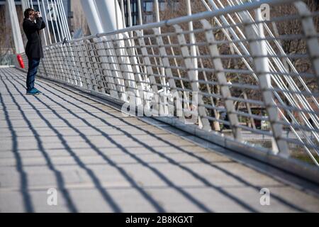 Ein Mann blickt auf die Aussicht von der Golden Jubilee Footbridge im Zentrum Londons, nachdem Premierminister Boris Johnson Theater, Pubs und Restaurants im ganzen Land schließen ließ, als die Regierung die Menschen dazu anregte, Ratschläge zur sozialen Distanzierung während des Coronavirus-Ausbruchs zu befolgen. Stockfoto