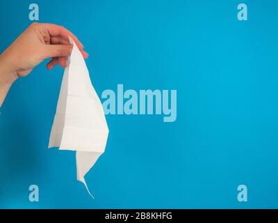 Hand mit Gewebe auf blauem Hintergrund mit Kopierbereich Stockfoto
