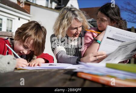 Image ©lizenziert für Parsons Media. 22/03/2020. London, Großbritannien. Hausschulbildung aufgrund des Coronavirus. Karen Attwood, die zu Hause ihre Kinder Isaac 7 (links) und Yasmin 9 (rechts) in ihrem Hintergarten in Nord-Ost-London schult, während sie die Frühlingssonne genießen. Ab Montag, 23. März, werden Kinder in ganz Großbritannien aufgrund des Coronavirus von zu Hause aus unterrichtet. Bild von Andrew Parsons/Parsons Media Stockfoto