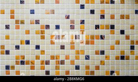 Nahaufnahme von bunten Mosaikfliesen für den Hintergrund. Mosaikfliesenhintergrund aus weiß, gelb und schwarz. Stockfoto