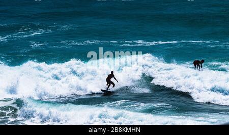 Surfer in Uluwatu surfen in einem der besten Surforte der Welt. Surfer aus der ganzen Welt kommen nach Uluwatu, um die Wellen zu schlagen Stockfoto