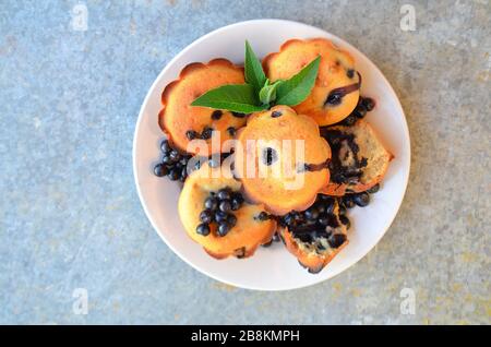 Draufsicht. Muffins mit Blaubeeren. Hausgemachte Blaubeer-Muffins mit Beeren auf einem Teller Stockfoto