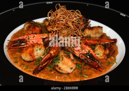 Gegrillter kochender Tigergarnelen Risotto, italienischer Reis, der in reicher aromatisierter Rock-Hummersoße gekocht wird Stockfoto
