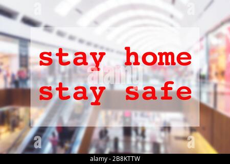 Bleib zu Hause Stay Safe Konzept mit verschwommenem Bild von Einkaufszentrum und rotem Text. Verbringen Sie hochwertige Zeit in der Familie zu Hause während der Pandemie-Quarantäne von Coronavirus Stockfoto