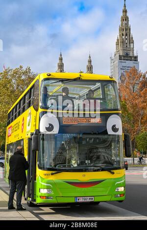 WIEN, ÖSTERREICH - NOVEMBER 2019: Person, die an einer Bushaltestelle in der Stadt in einen Touristenbus mit Doppeldeck fährt, der von der Vienna Sightseeing betrieben wird. Stockfoto