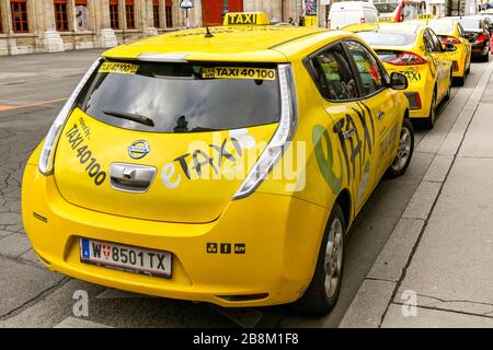 WIEN, ÖSTERREICH - NOVEMBER 2019: Hinter anderen Taxis geparktes Elektrotaxi-Taxi auf einer Straße in der Wiener Innenstadt. Stockfoto