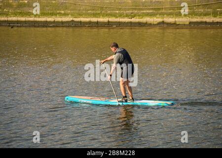 SWANSEA, WALES - JULI 2018: Person, die sich auf einem Paddle-Brett auf dem River Tawe in der Nähe des Yachthafens Swansea aufsteht Stockfoto