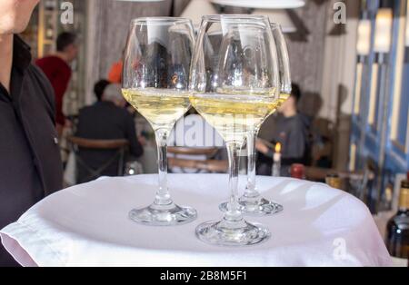 Kellner, der Gläser mit Wein auf dem Tablett hält - Partyhintergrund Stockfoto