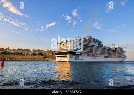 Valletta, Malta - 16. Oktober 2019: Kreuzfahrtschiff MSC Bellissima, das bei Sonnenuntergang den Grand Harbour im Mittelmeer verlässt Stockfoto