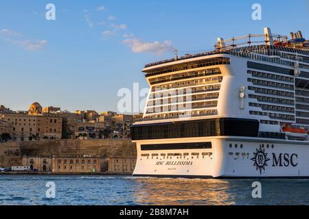 Valletta, Malta - 16. Oktober 2019: Kreuzfahrtschiff MSC Bellissima, das bei Sonnenuntergang den Grand Harbour im Mittelmeer verlässt Stockfoto