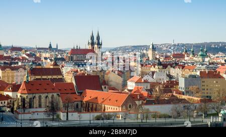 Gesamtansicht der Prager Altstadt kurz nach Sonnenaufgang, sonniger Frühlingstag mit blauem Himmel. Kloster St. Agnes im Vordergrund, Dach und Türme der Kirche Stockfoto