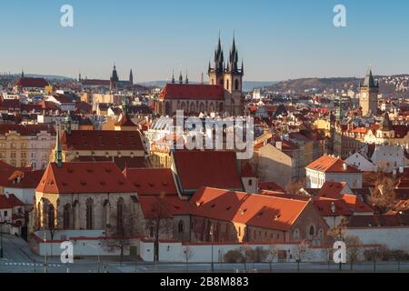 Gesamtansicht der Prager Altstadt kurz nach Sonnenaufgang, sonniger Frühlingstag mit blauem Himmel. Kloster St. Agnes im Vordergrund, Dach und Türme der Kirche Stockfoto