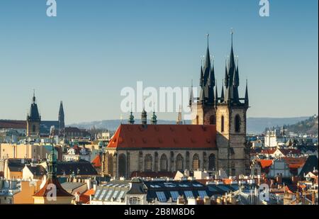 Gesamtansicht der Prager Altstadt kurz nach Sonnenaufgang, sonniger Frühlingstag mit blauem Himmel. Das Dach und die Türme der Kirche unserer Lieben Frau vor Tyn in m Stockfoto