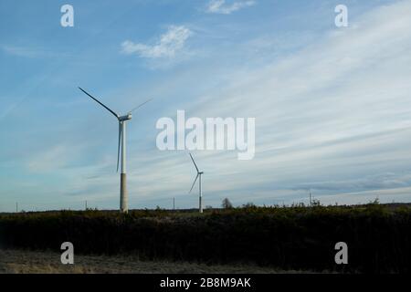 Windkraftanlagen im Windpark gegen bewölktem Himmel Stockfoto