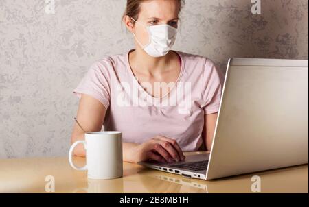 Coronavirus. Junge Geschäftsfrau, die von zu Hause aus mit Schutzmaske arbeitet. Geschäftsfrau in Quarantäne für Coronavirus mit Schutzmaske. Wor Stockfoto