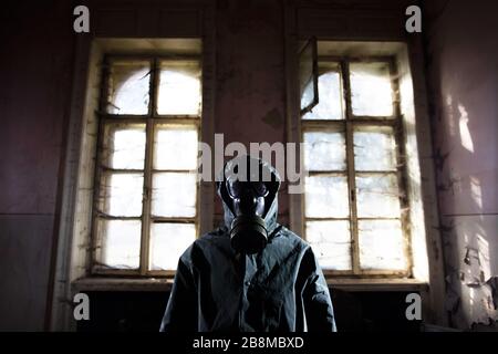 Postalyptischer Überlebender in Gasmaske in einem zerstörten Gebäude. Umweltkatastrophe, konzept von armageddon. Stockfoto